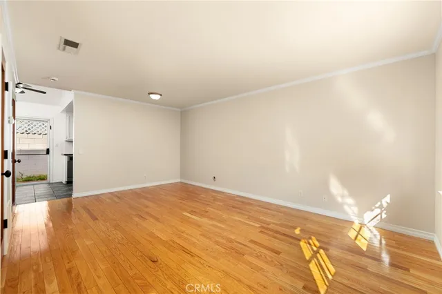 a view of a big room with wooden floor and windows