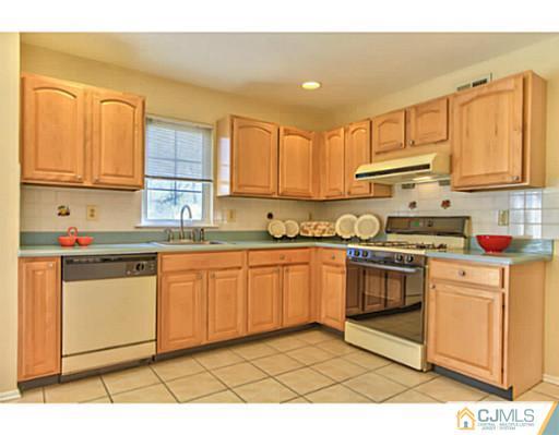 2 Stratton Road Old Bridge, NJ 07747 - Photo 9 of 24 a kitchen with stainless steel appliances granite countertop a stove a sink and white cabinets