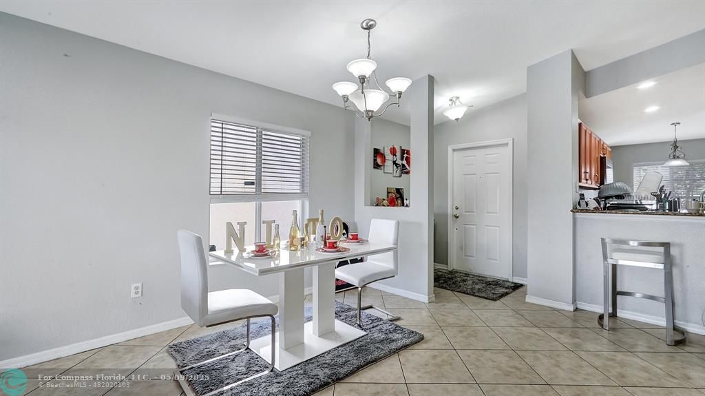 4558 Southwest 125th Lane Miramar, FL 33027 - Photo 12 of 47 a dining room with granite countertop a table and chairs in it