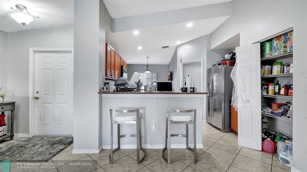 4558 Southwest 125th Lane Miramar, FL 33027 - Photo 13 of 47 a living room with stainless steel appliances furniture a rug and a bookshelf