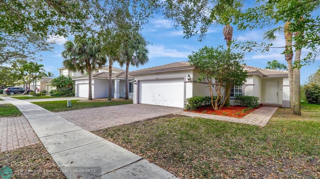 4558 Southwest 125th Lane Miramar, FL 33027 - Photo 2 of 47 a front view of a house with a yard and trees