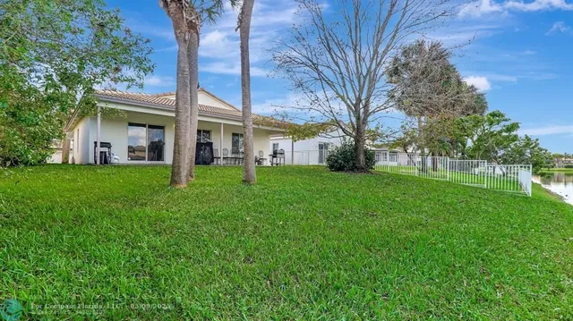a view of a house with a big yard and large tree