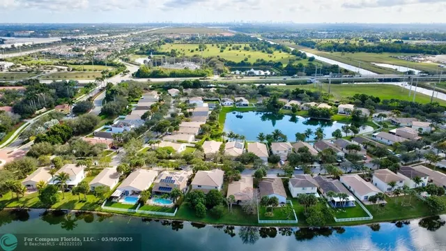 an aerial view of residential houses with outdoor space and trees