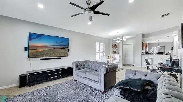 a living room with furniture and a dining table with kitchen view