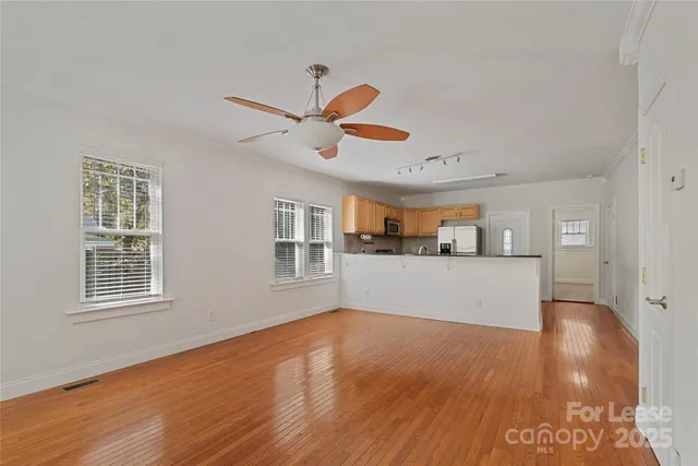 a view of a livingroom with wooden floor and a ceiling fan