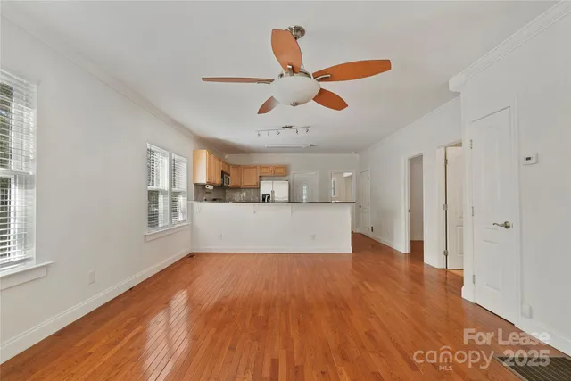 a view of a kitchen with wooden floor and a ceiling fan
