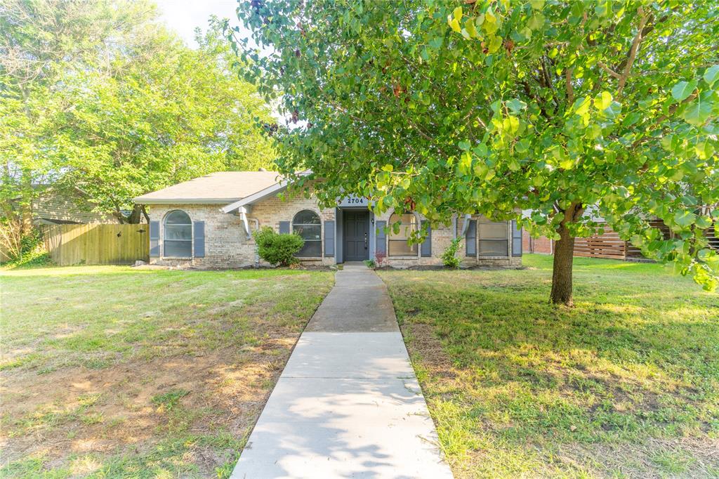 a front view of a house with yard and green space