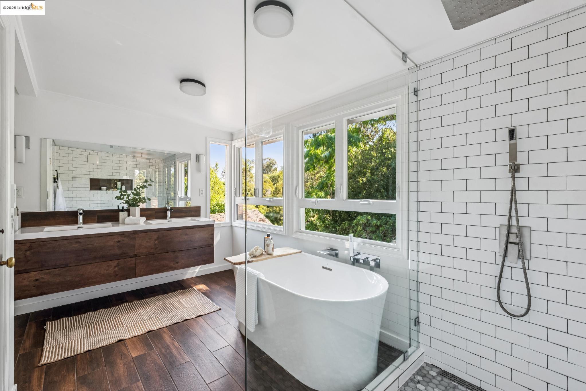 4479 Elinora Avenue Oakland, CA 94619 - Photo 23 of 47 Bathroom with a stall shower, a freestanding bath, double vanity, tile walls, and dark wood finished floors