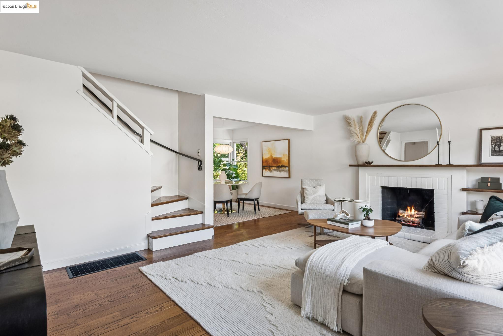 4479 Elinora Avenue Oakland, CA 94619 - Photo 6 of 47 Living area with dark wood-style floors, a brick fireplace, and stairs