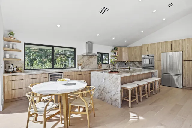 a very nice looking living room with a large window and dining table