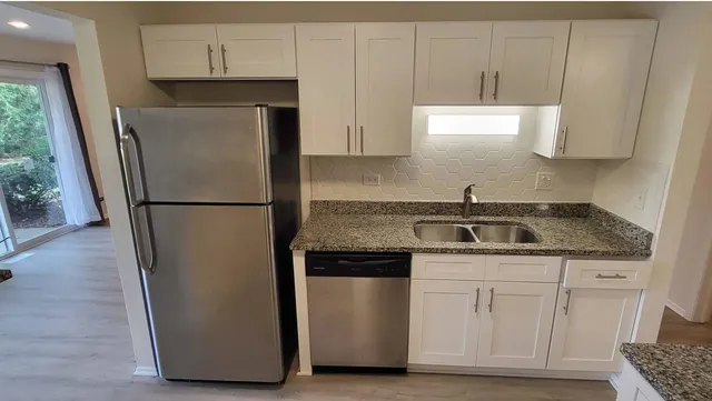 a kitchen with a refrigerator sink and cabinets