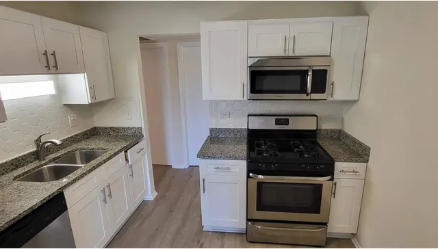 a kitchen with granite countertop a stove and a sink