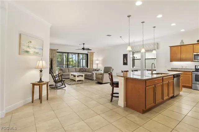 a large kitchen with kitchen island a sink white cabinets and stainless steel appliances