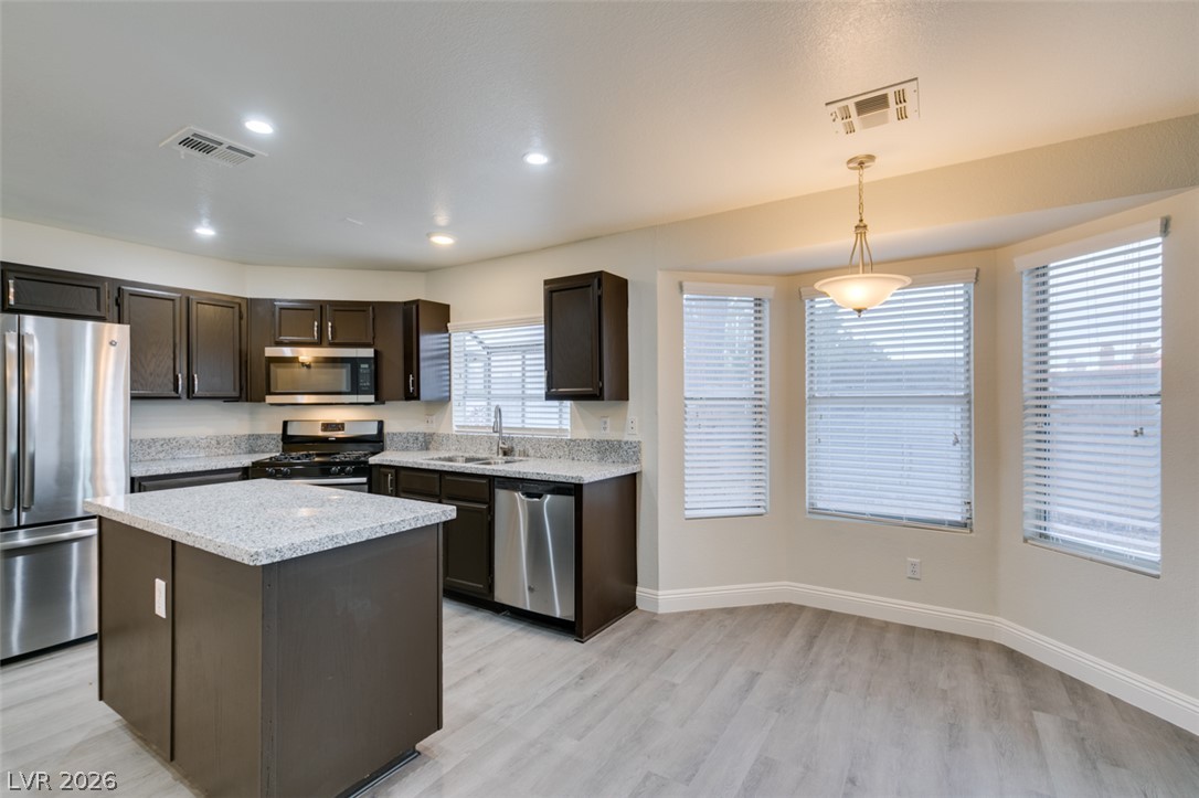 1738 Toltec Circle Henderson, NV 89014 - Photo 39 of 46 A well-appointed kitchen featuring a functional island, modern appliances, and sun-filled dining space.