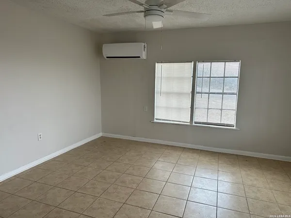 an empty room with a ceiling fan and a window