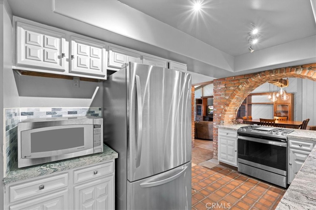 222 Village Square Fillmore, CA 93015 - Photo 12 of 39 a kitchen with stainless steel appliances granite countertop a stove a refrigerator and a microwave