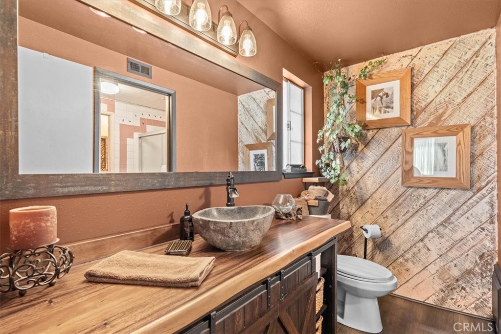 222 Village Square Fillmore, CA 93015 - Photo 18 of 39 a bathroom with a granite countertop sink a toilet and a mirror