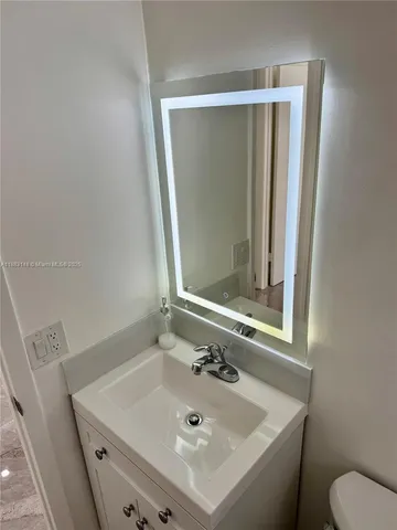 a bathroom with a sink a toilet and mirror