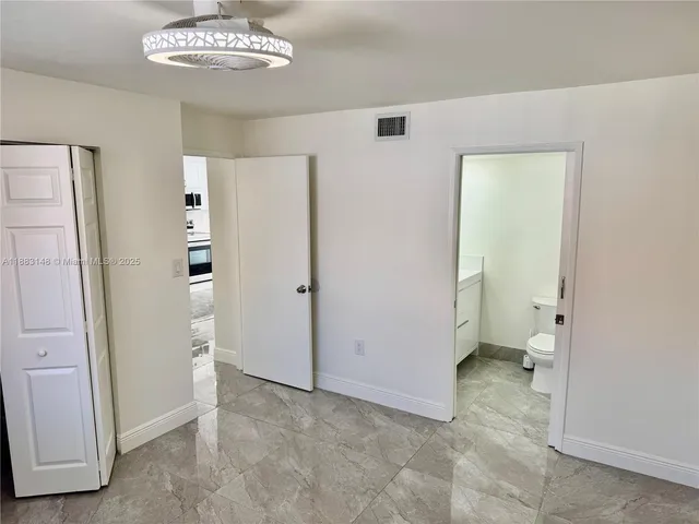 wooden floor in an empty room with a bathroom
