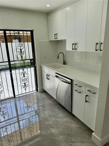 a kitchen with white cabinets and a stove top oven
