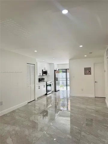 a view of kitchen with refrigerator and window