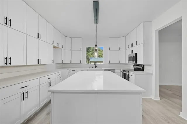 a view of empty room with wooden floor and window