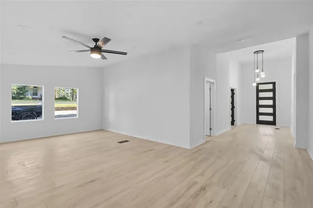 a view of an empty room with wooden floor and closet