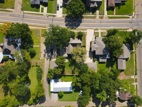 an aerial view of residential houses with outdoor space and trees