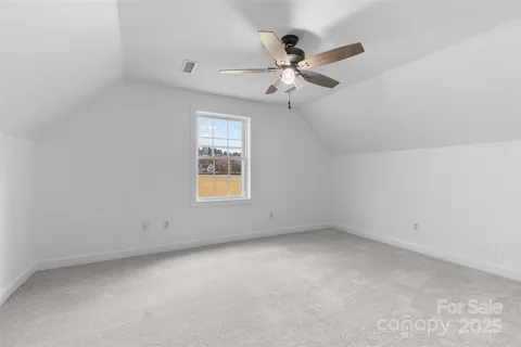 an empty room with a window and ceiling fan