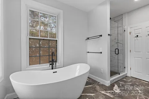 a white bath tub sitting next to a shower