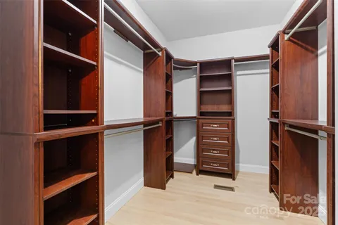 a view of walk in closet with clothes