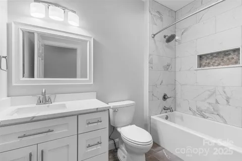 a bathroom with a toilet sink vanity tub and shower
