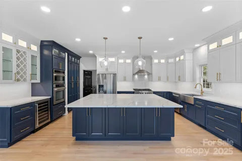 a large kitchen with kitchen island a sink stainless steel appliances and cabinets