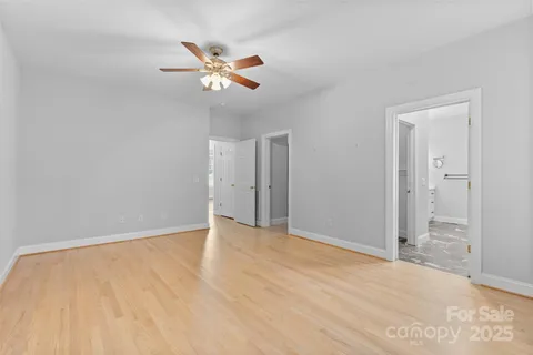a view of an empty room and chandelier fan