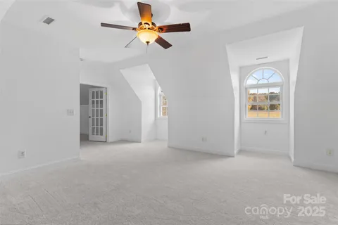 an empty room with a window and a ceiling fan