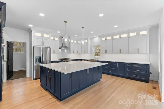 a kitchen with a stove a sink a refrigerator and a oven