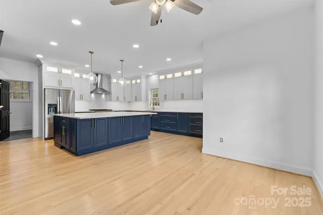 a large kitchen with a chandelier and kitchen view
