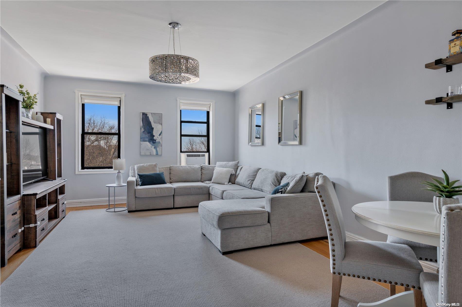 a living room with furniture a chandelier and a flat screen tv