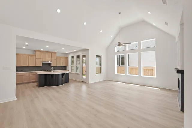 a view of kitchen with stainless steel appliances kitchen island wooden cabinets and a couch