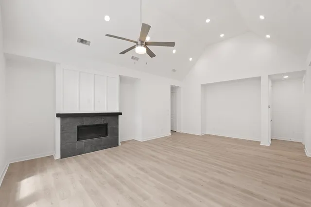 a view of empty room with wooden floor and fireplace