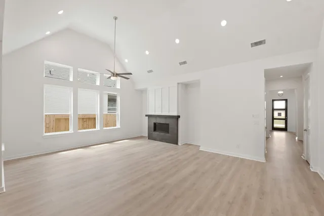 an empty room with windows and fireplace