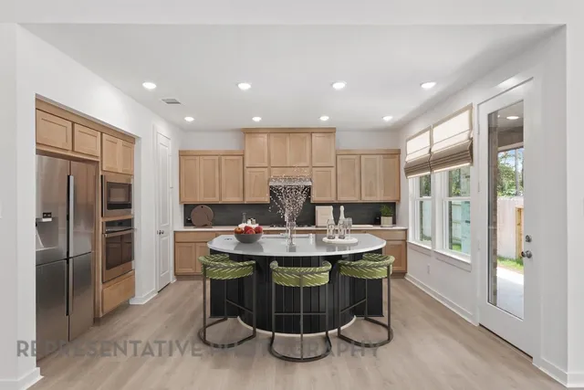 a kitchen with a refrigerator and a dining table