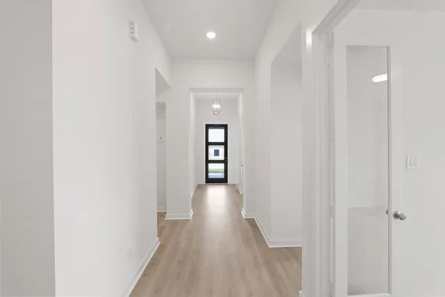 a view of a hallway with wooden floor and staircase