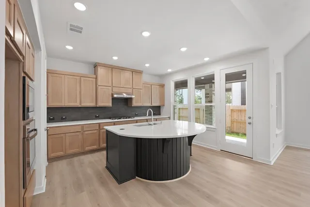 a kitchen with kitchen island sink stove and refrigerator