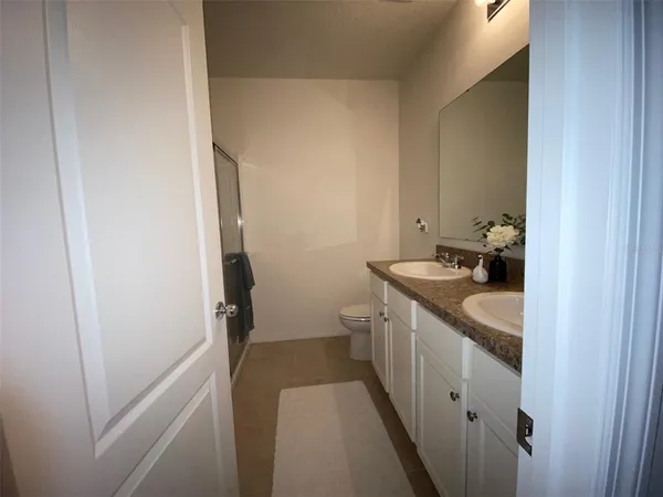 a bathroom with a sink and mirror with toilet