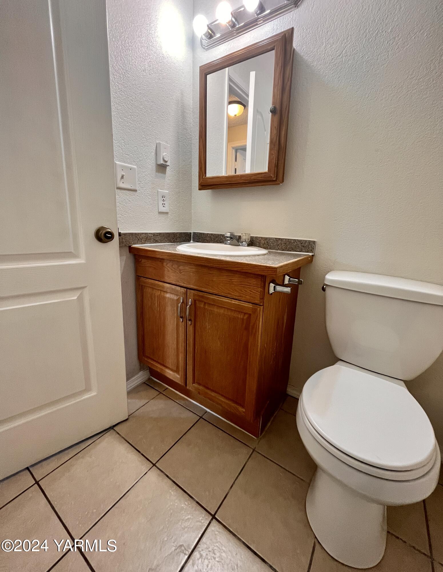 1403-1405 Roosevelt Avenue Yakima, WA 98902 - Photo 5 of 14 a bathroom with a toilet a sink and mirror