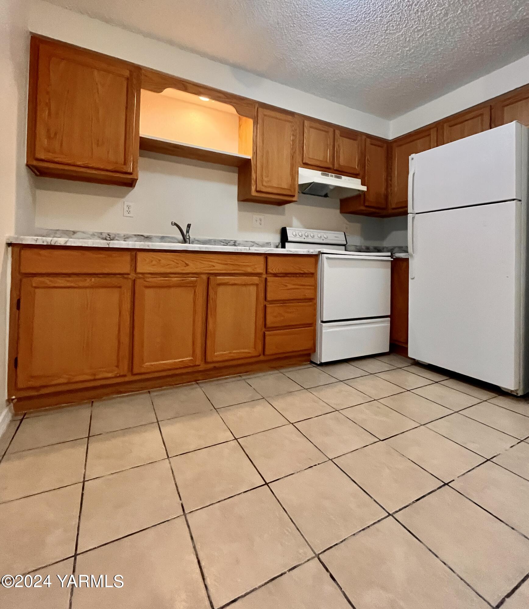 1403-1405 Roosevelt Avenue Yakima, WA 98902 - Photo 6 of 14 a kitchen with a cabinets and white appliances
