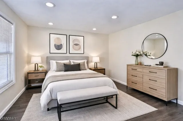 a bedroom with a bed a mirror and night stand