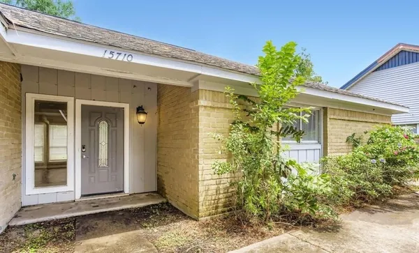 a front view of a house with plants