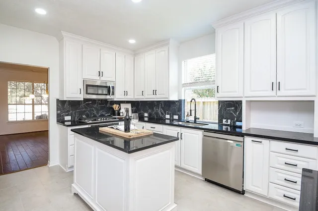 a kitchen with stainless steel appliances granite countertop a sink stove and cabinets